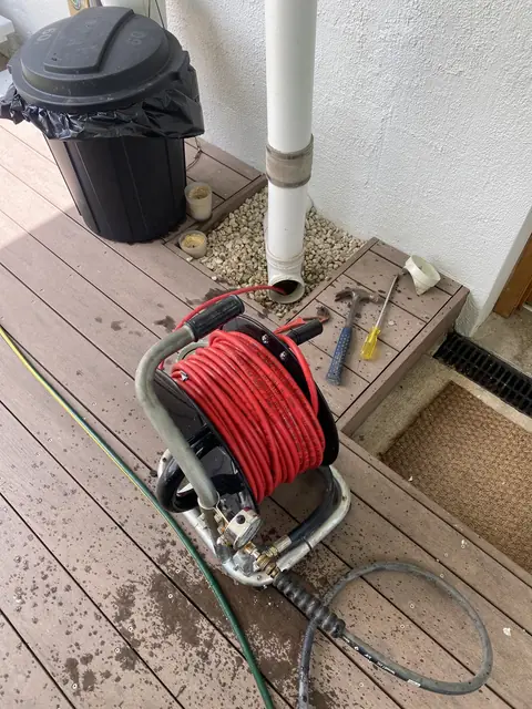 A drain jetter hose reel set up on a timber deck
